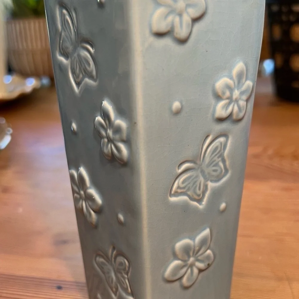 Small baby blue bud vase. With “butterflies and flowers.”